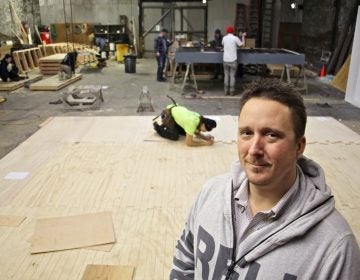 Matthew Lewandowski stands in the Philadelphia Scenic Works workshop where set builders from three different small theater groups find space to work at the same time.