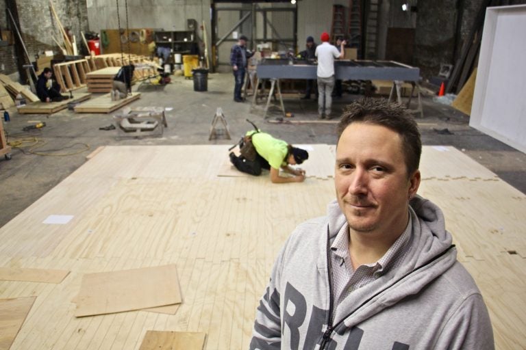 Matthew Lewandowski stands in the Philadelphia Scenic Works workshop where set builders from three different small theater groups find space to work at the same time.