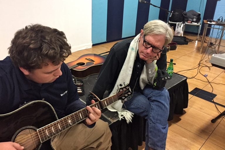 Singer/songwriter Sam Baker (right) sits with 16-year-old Andrew Hart, who suffers from severe depression, and has struggled with homelessness and abuse. He taught himself to play the guitar.
