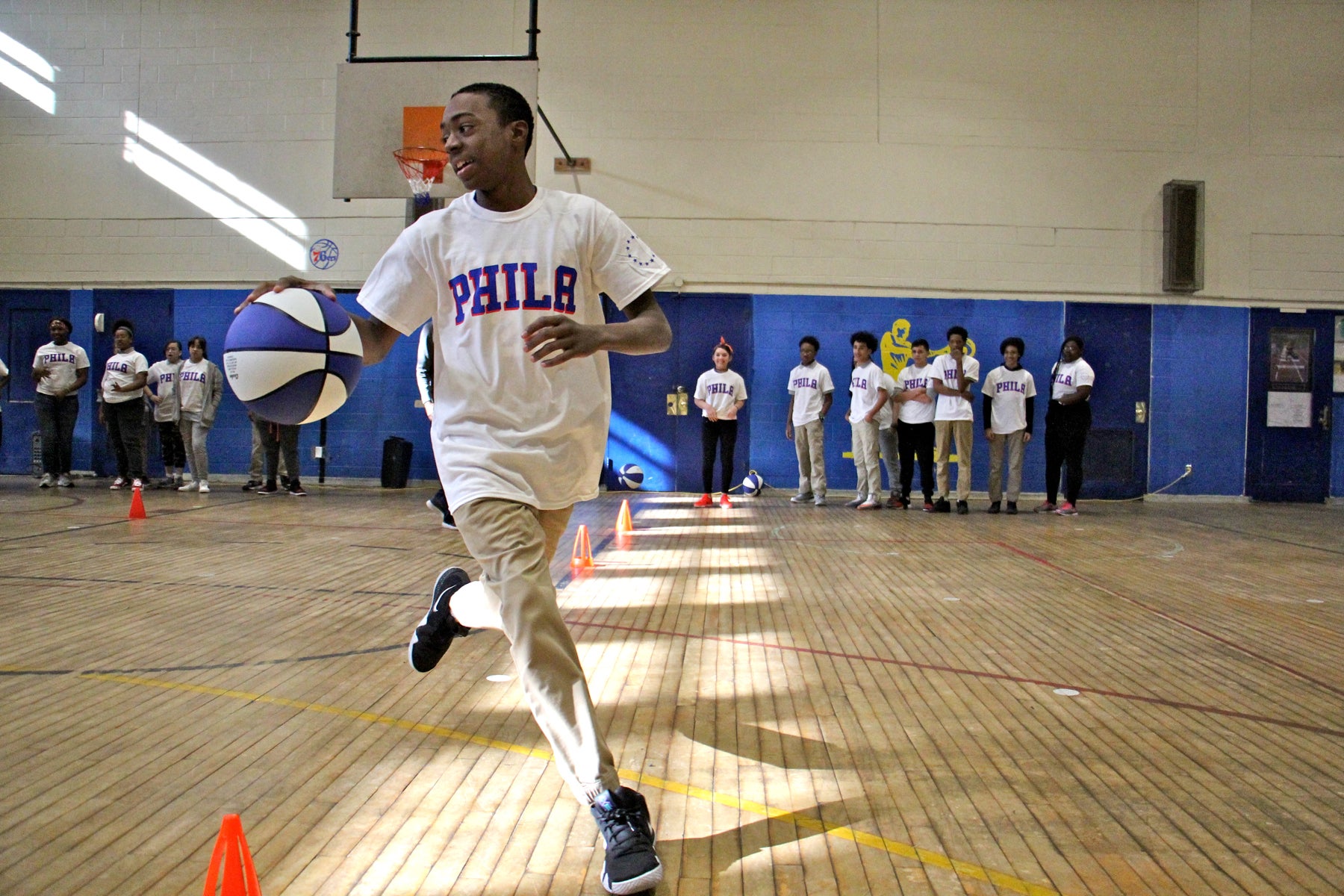 Eighth grader Phillip Bland and his classmates enjoy a Sixers basketball clinic at their school. 