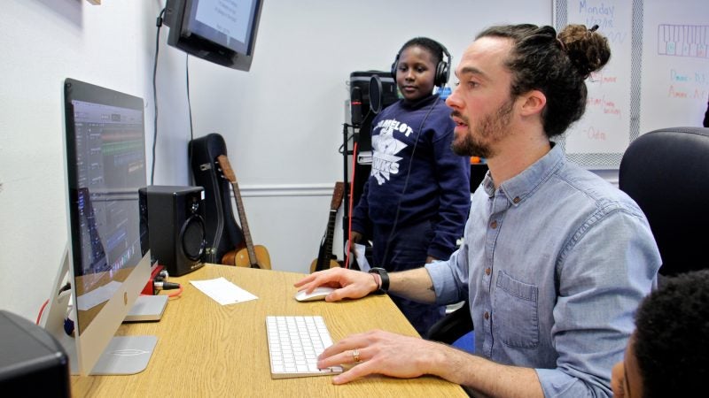 Counselor Luke O'Brien helps Khalif Henry record a track. (Emma Lee/WHYY)