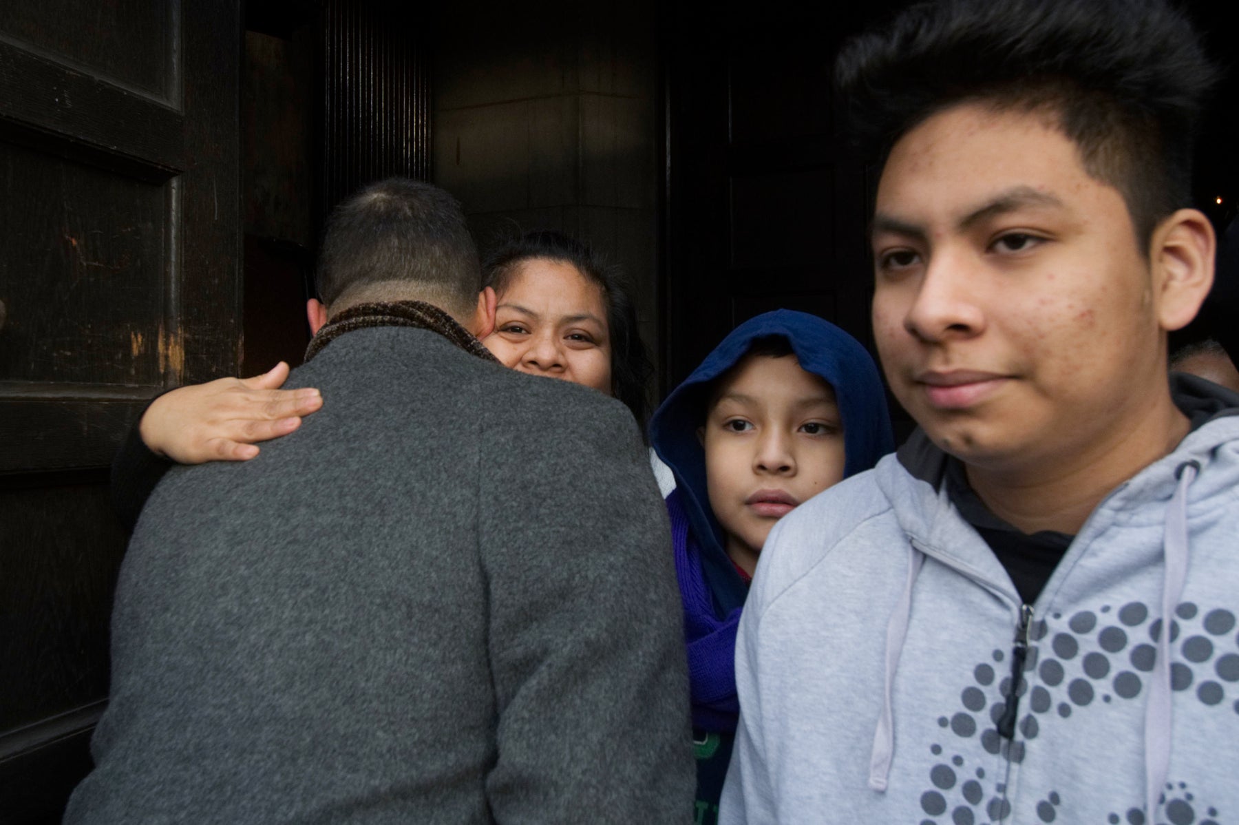 State Rep. Chris Rabb and Camela Apolonio Hernandez embrace in the doorway of Church of the Advocate in North Philadelphia as her four children leave sanctuary to go back to school for the first time since the family received a deportation order. 