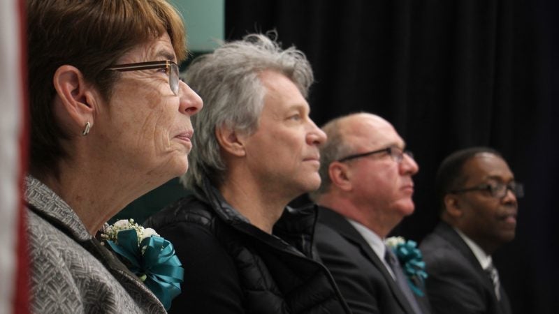 Sister Mary Scullion of Project HOME listens to speakers during the ribbon cutting  ceremony for Hub of Hope, a homeless outreach and service center in the Center City subway concourse. With her are (from left) Jon Bon Jovi, whose Soul Foundation has helped to alleviate homelessness in Philadelphia, SEPTAS Board Chairman Pasquale Deon Sr., and City Council President Darrell Clarke. (Emma Lee/WHYY)