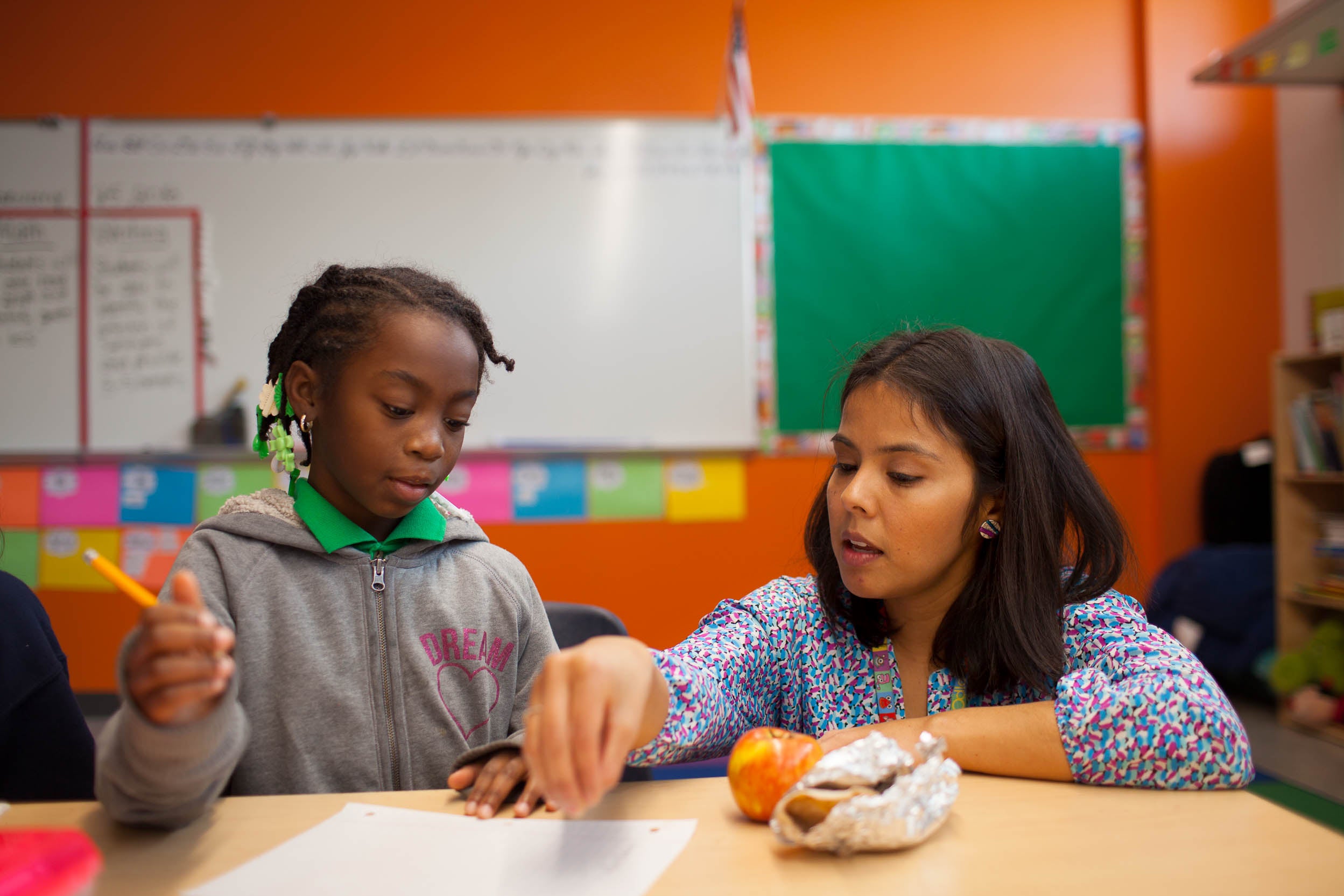 Maria Rocha helps a student with the morning warm-up in her third-grade science class.