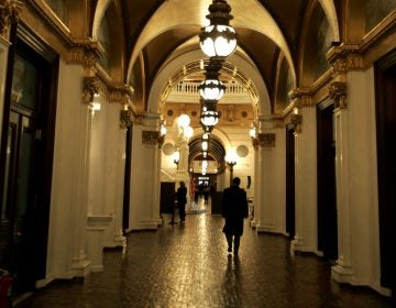 A man walks down a hall toward the light of the Capitol rotunda, in Harrisburg, Pa.