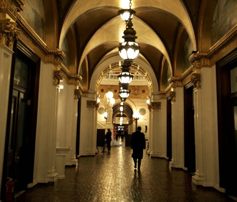 A man walks down a hall toward the light of the Capitol rotunda, Wednesday, March 15, 2006, in Harrisburg, Pa.