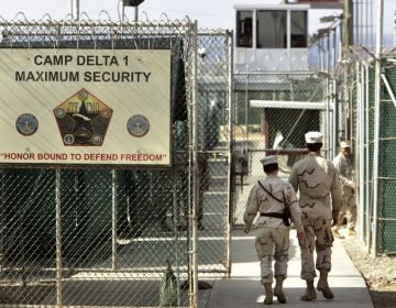 FILE - In this June 27, 2006 file photo, reviewed by a U.S. Department of Defense official, U.S. military guards walk within Camp Delta military-run prison, at the Guantanamo Bay U.S. Naval Base, Cuba.