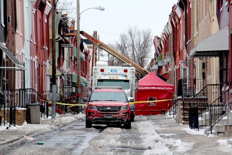 The investigation continues at the scene of a row house fire on North Colorado Street that killed a firefighter and a 61-year-old resident.