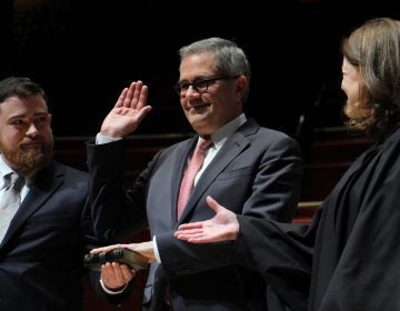 Philadelphia District Attorney Larry Krasner sworn in by his wife, Judge Lisa Millett Rau with son Nathan holding Bible.