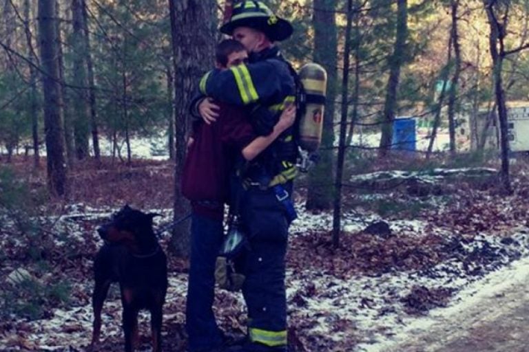 Tabernacle Fire Lt. Jason Penwell hugs his 15-year-old son after responding to a blaze that gutted his family's home Wednesday. (Maryann Smith)