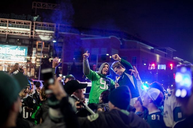 Eagles Fans celebrate near Xfinity Live after their win over the Minnesota Vikings in the NFC Championship Game Sunday. (Brad Larrison for WHYY)