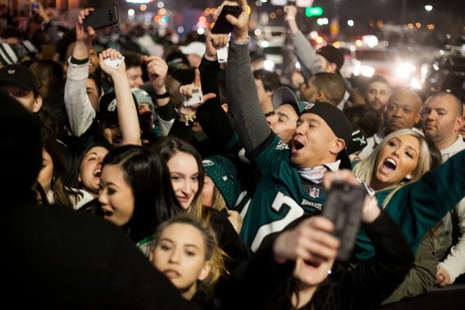 Eagles fans cheer outside of Xfinity Live after an Eagles touchdown in the NFC Championship Game against the Minnesota Viking Sunday Night. (Brad Larrison for WHYY)