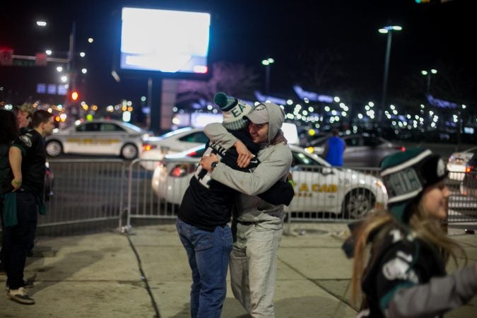 Eagles fans hug outside of Xfinity Live after an Eagles touchdown in the NFC Championship Game against the Minnesota Viking Sunday Night. (Brad Larrison for WHYY)