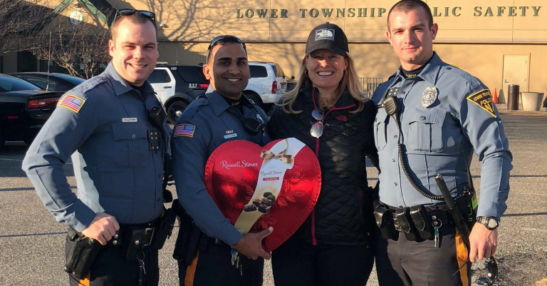 The dog's owner presents a gift to the three Lower Township Police officers that responded to the lake last Sunday. 