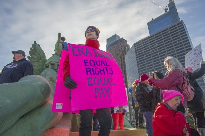 Lisa Hendrickson, of Mt. Laurel, a member of the Alice Paul Institute, NJ stands with her sign at Logan Circle. (Jonathan Wilson for WHYY)