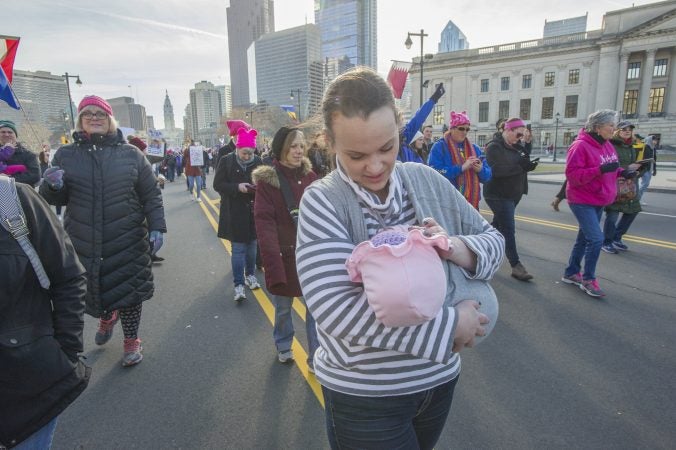 Madeline Beach carries her one year old daughter Grace Beach-DiDonato along the Parkway. (Jonathan Wilson for WHYY)