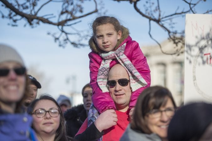 David Jones holds his niece Kaelyn Jones on his shoulders during the march. (Jonathan Wilson for WHYY)