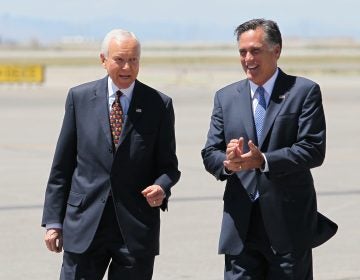 In this June 8, 2012 file photo, Mitt Romney, right, laughs walking side-by-side with Sen. Orrin Hatch, R-Utah, who met him on the tarmac at Salt Lake International Airport.