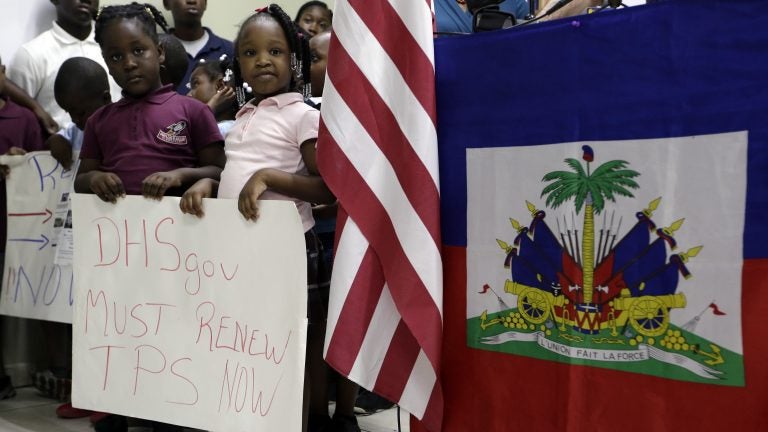 Children hold signs at a November news conference in Miami in support of renewing temporary protected status for immigrants from Central America and Haiti. (Lynne Sladky/AP)