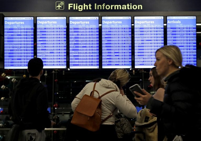 Travelers walk and check their flight information in Terminal 3 at Chicago's O'Hare International Airport in December