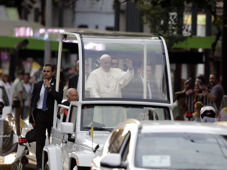 Pope Francis waves at followers on his way to the Apostolic Nunciature in Santiago, Chile, on Monday.
