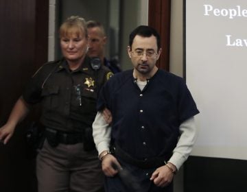 Larry Nassar is escorted into court in Lansing, Mich., on Wednesday, where he was sentenced to 40 to 175 years in prison. (Carlos Osorio/AP)