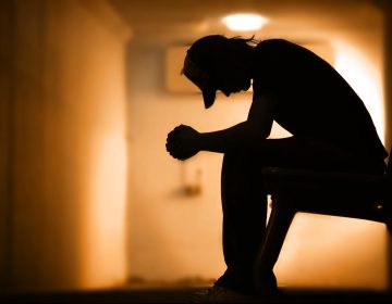 Young man with hands clasped together praying