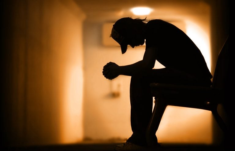 Young man with hands clasped together praying