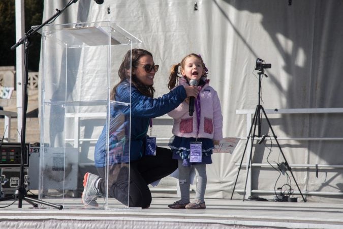 Laura Arblaster helps her 3 year old daughter, Elizabeth Zangrilli, raise her voice at the 2018 Women's March on Philadelphia, January 20, 2018. (Emily Cohen for WHYY)