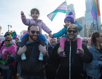 Josh Gordon (from left) holds 3-year-old Cece while she holds hands with her best friend,    Reva, carried by her father, Demitry, at the 2018 Womens March on Philadelphia in January. (Emily Cohen for WHYY)