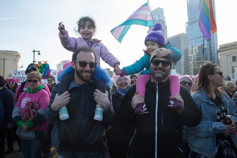 Josh Gordon (from left) holds 3-year-old Cece while she holds hands with her best friend,    Reva, carried by her father, Demitry, at the 2018 Womens March on Philadelphia in January. (Emily Cohen for WHYY)