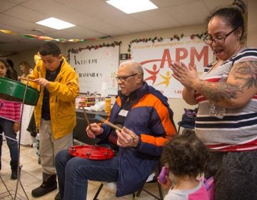 Asaf Barrios, 11, jams out on his steele drum accompanied by his father, Raul, at APM's Three Kings Day/Octavious celebration for displaced families from Puerto Rico in North Philadelphia on January 12 2018. (Emily Cohen for WHYY)
