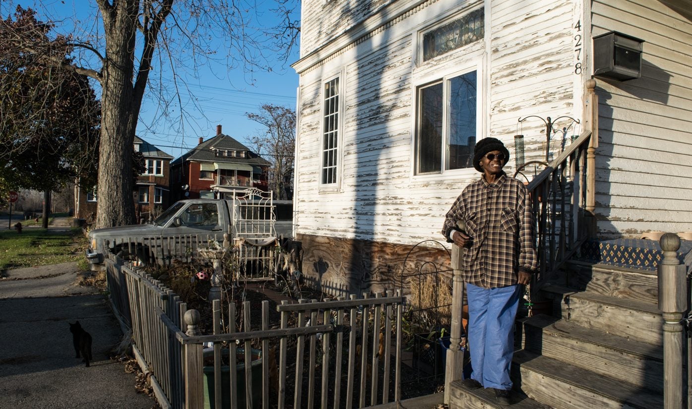 Gloria Duncans-Kidd stands on the porch of her Detroit home.