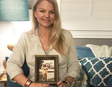 Christine Caria in her home, holding a picture of her as a child in Lake Tahoe. It's her 