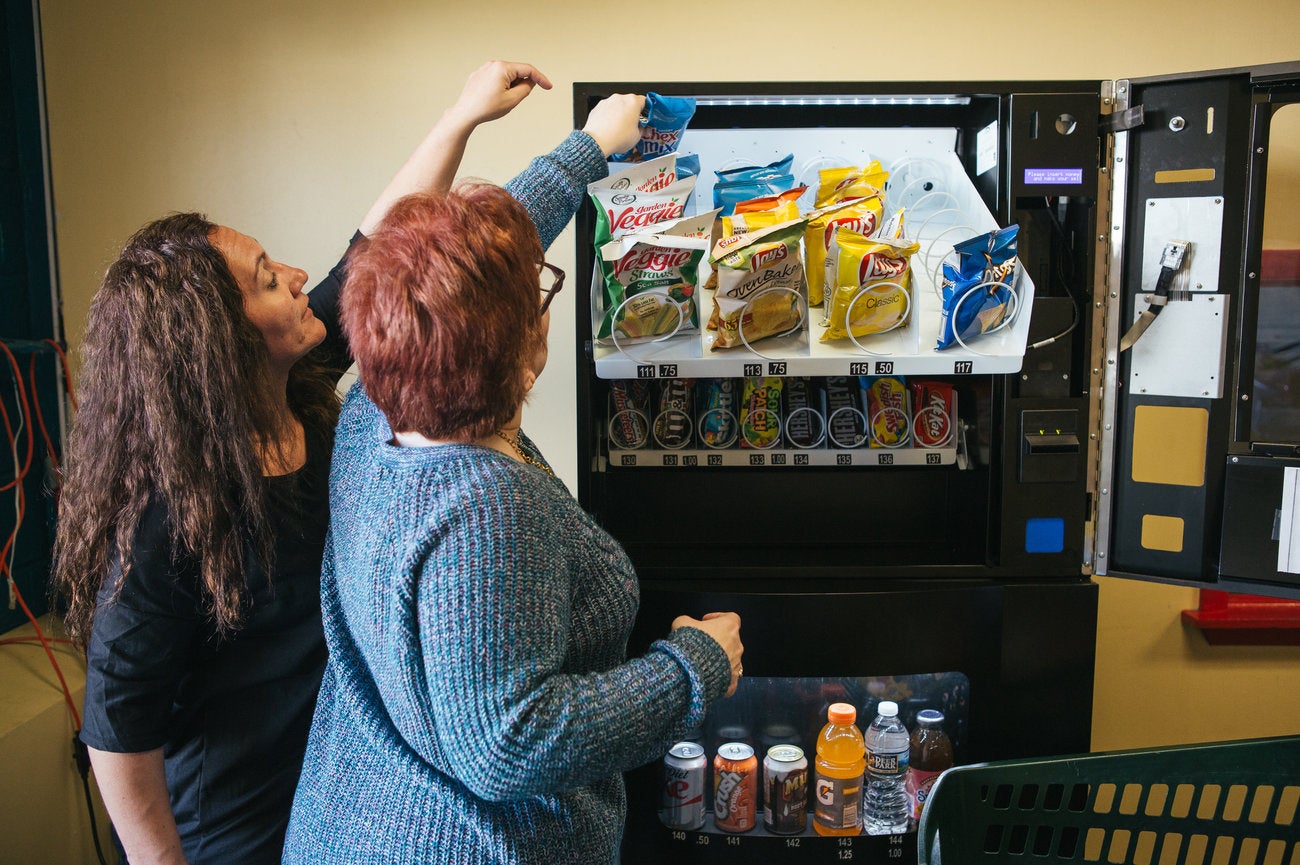 Erica Francis, a direct support professional, helps Pauline as they restock a vending machine at Arc of Northeastern Pennsylvania. 