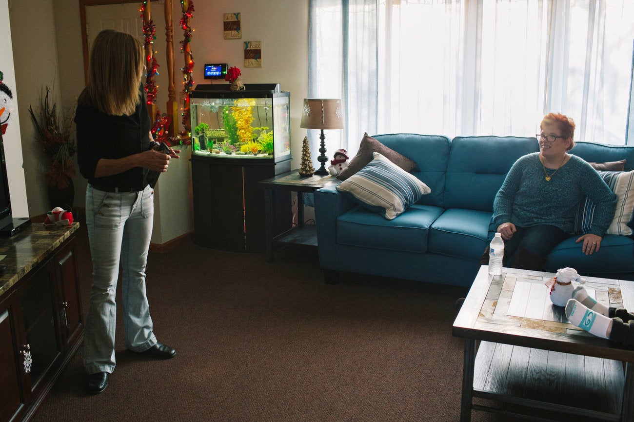 Roxanne Kiehart, one of the caretakers at Pauline's group home, puts in a movie for Pauline and a housemate after they returned home from a day program.