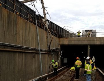 Workers assessing damage from a Conrail train's collision with a PATCO power pole.