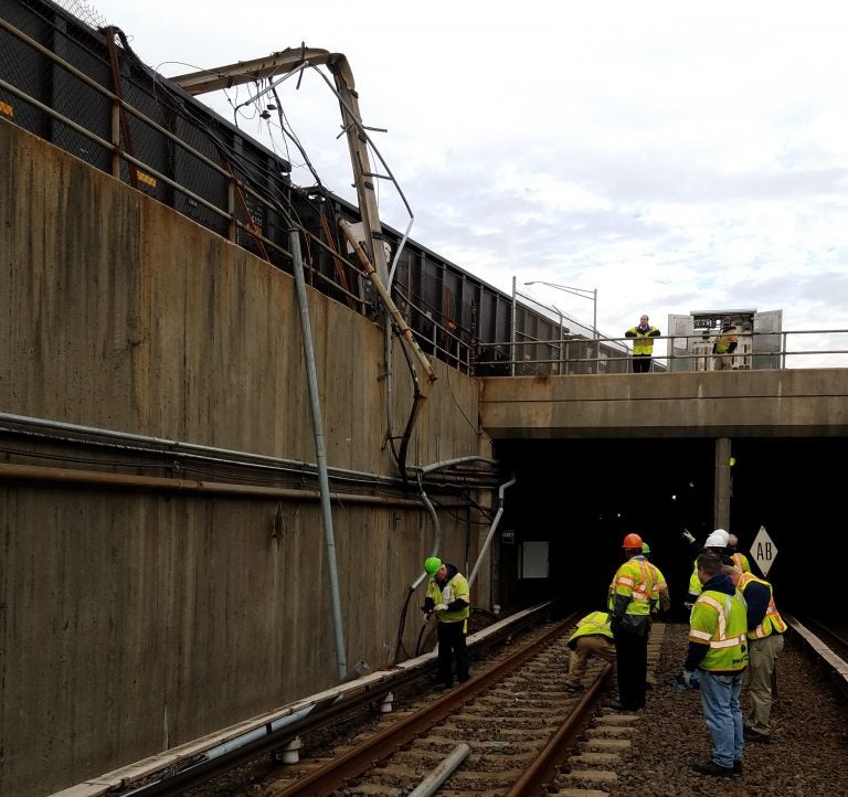 Workers assessing damage from a Conrail train's collision with a PATCO power pole.