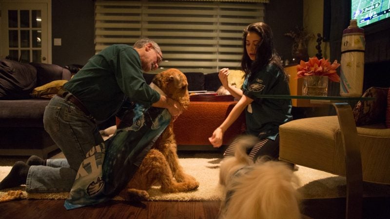 Barry Stein and Rachel Kitchenoff make sure their dogs are feeling the Eagles pride while watching the NFC chamionship game in Wynnewood. (Emily Cohen for WHYY)