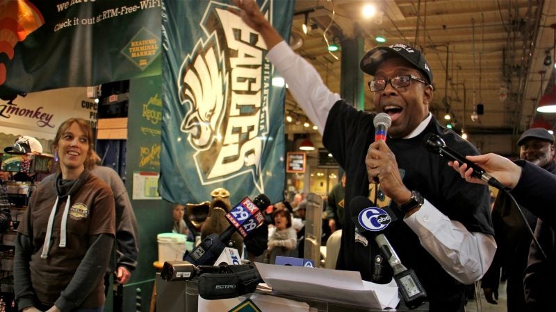 City Council President Darrell Clarke sings the Eagles fight song at Reading Terminal Market after announcing a bet with his Boston counterpart, Andrea Campbell, over the outcome of the Super Bowl. (Emma Lee/WHYY)