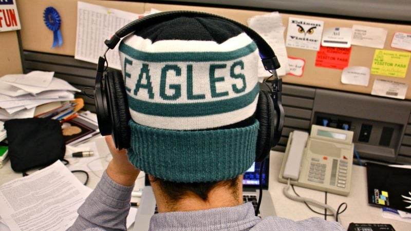 WHYY education reporter Avi Wolfman-Arent works in his Eagles hat. (Emma Lee/WHYY)