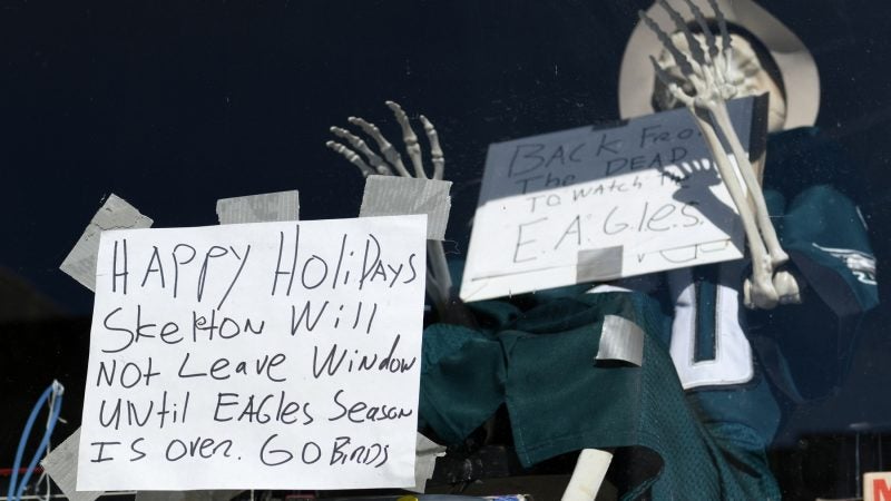 A skeleton in an Eagles jersey sits in the window of a store in Manayunk. (Bastiaan Slabbers for WHYY)