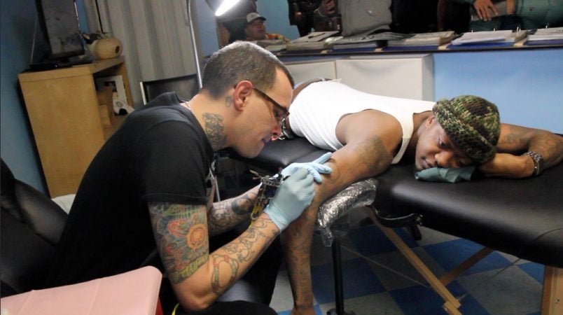 Ronald Coleman of South Philadelphia gets a classic Eagles logo tattoo at Moo Tattoo shop on South Street Wednesday morning. (Kimberly Paynter/WHYY)