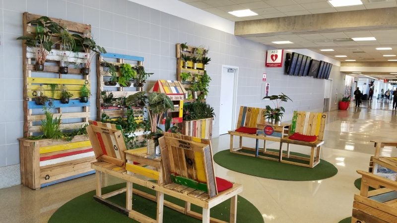 A seating area/book trade designed by Leah Douglas is made from leftover pallets. The book trade is stocked with books left behind in airplanes. (Peter Crimmins/WHYY)