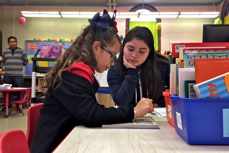 High School senior Shalia Alejandro (center) helps Soriely Quinonez, a student at Cramp Elementary School.