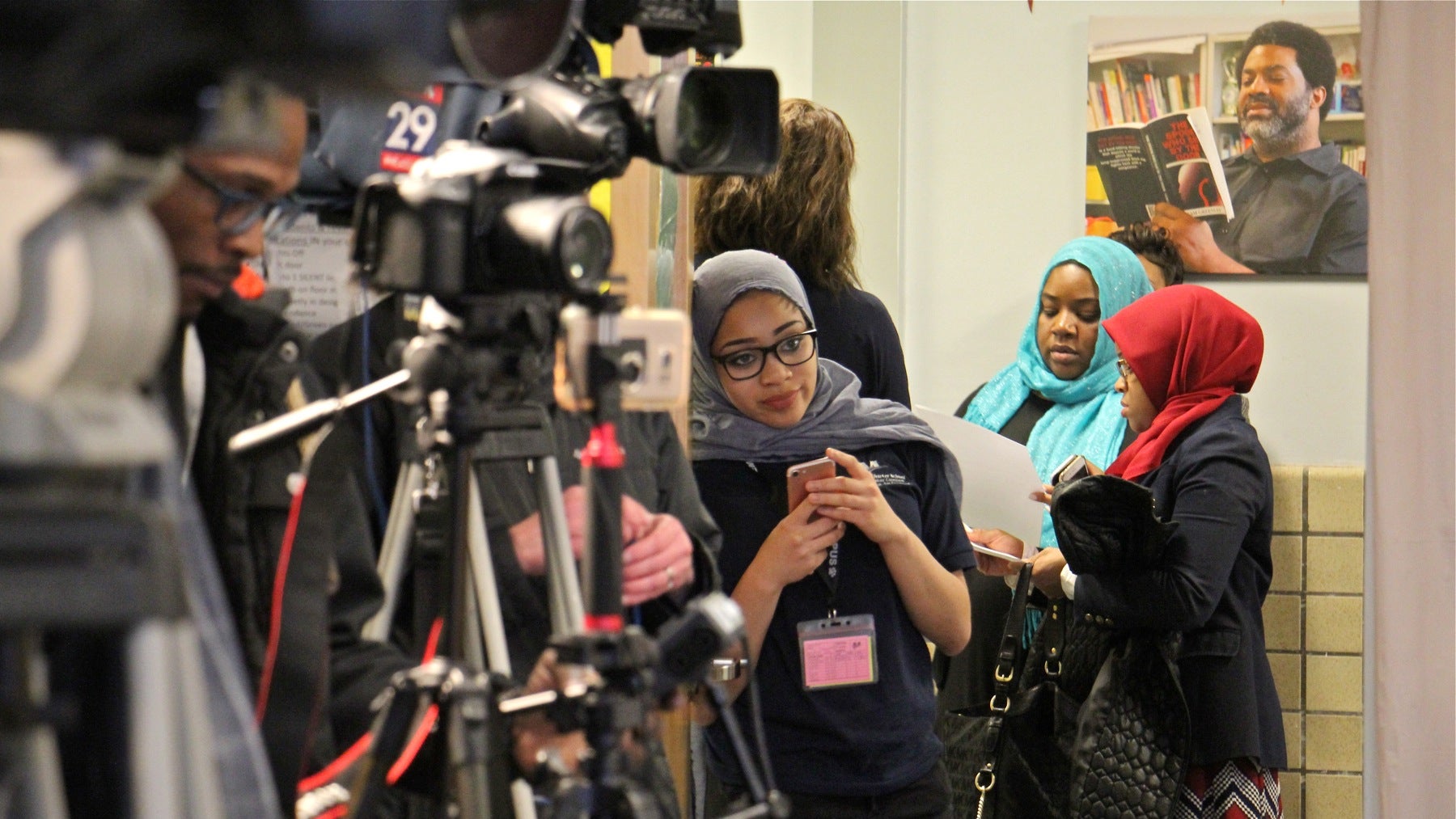 Nasihah Thompson-King, a Mastery Shoemaker Charter School basketball player who was benched because she had not obtained a waiver to wear her hijab, looks into a room full of media representatives before a press conference at her school. 