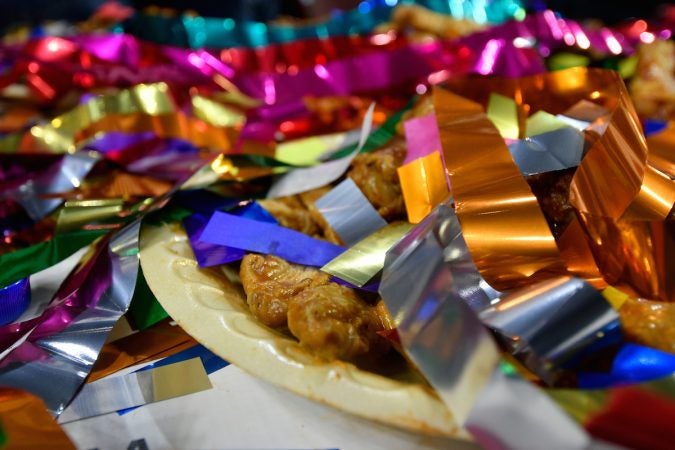 Confetti covers left over wings after competitive eater Molly Schuyler takes the crown for winning the Wing Bowl 26, at the Wells Fargo Center, on Friday.  (Bastiaan Slabbers for WHYY)