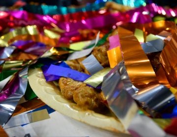 Confetti covers left over wings after competitive eater Molly Schuyler takes the crown for winning the Wing Bowl 26, at the Wells Fargo Center, on Friday.  (Bastiaan Slabbers for WHYY)