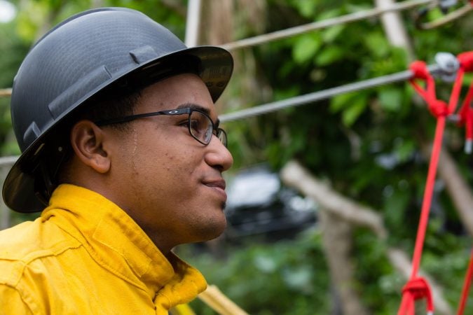 A member of a construction crew in El Yunque National Forest waits to send supplies down the hill on a custom-made zip line.