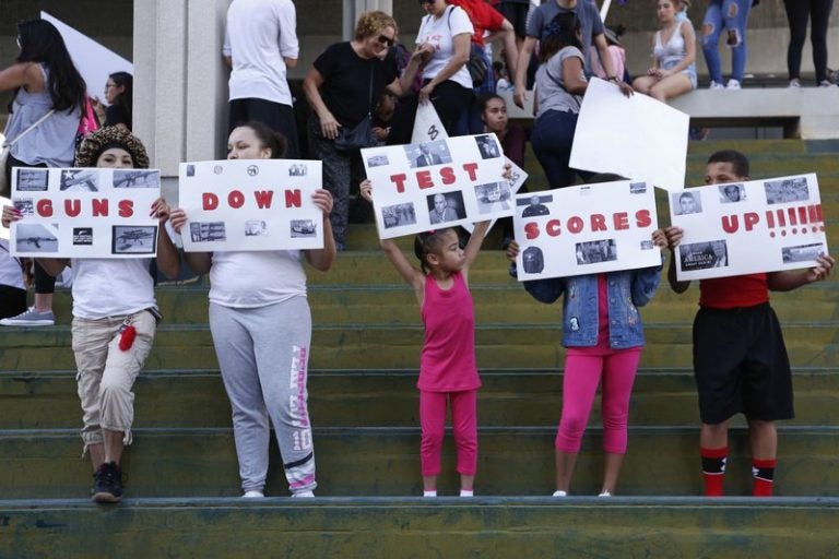 A group holds signs reading, “Guns Down Test Scores Up” during a protest in Fort Lauderdale, Florida. (AP Photo/Brynn Anderson)